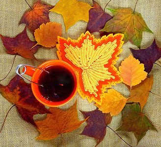 秋叶背景下带茶的红杯