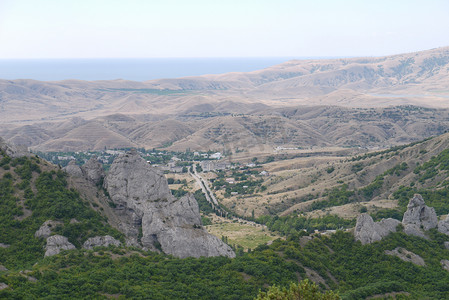 这条路在绿色的山坡之间通往山谷中的一个小村庄。