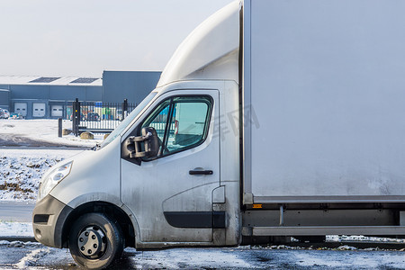 冬季白色停放的货车，背景是仓库，物流和运输车辆