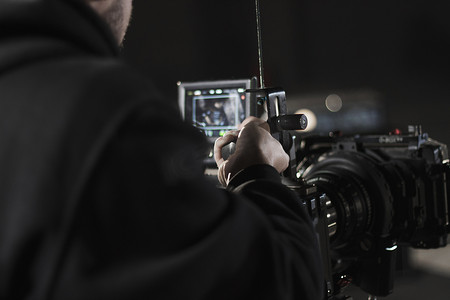 专业摄像师拿着安装在简单钻机上的相机。