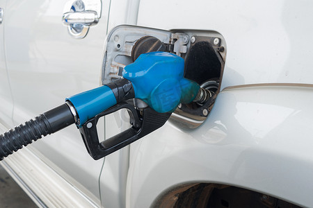 在加油站将燃料释放到汽车中的蓝色燃料喷嘴