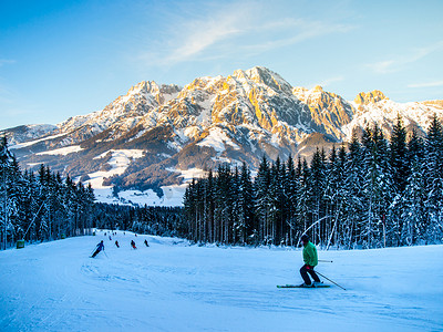 阳光明媚的冬日早晨，人们在山区度假胜地的滑雪坡上