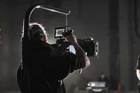 相机录像摄影照片_专业摄像师拿着安装在简单钻机上的相机。