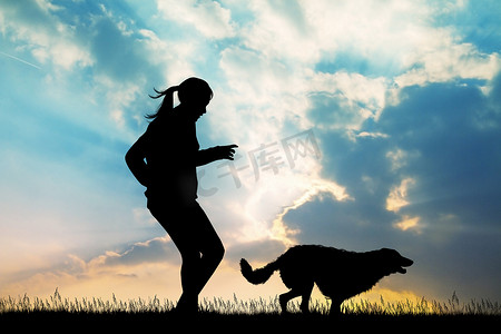 奔跑乌龟摄影照片_女孩在日落时与狗一起奔跑
