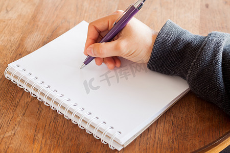 女人手用笔在笔记本上写字