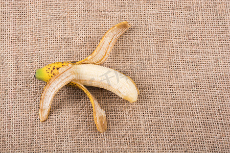 单个黄色有雀斑的香蕉被剥皮