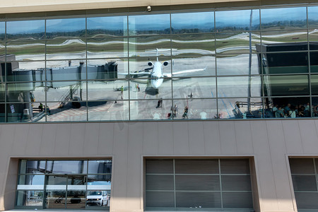 喷气式客机飞机在机场航站楼玻璃窗中的反射