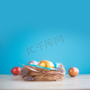 彩蛋蓝色摄影照片_用鸡蛋装饰的复活节巢