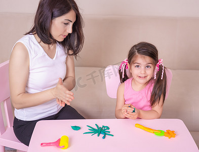妈妈和可爱的小女孩一起玩橡皮泥