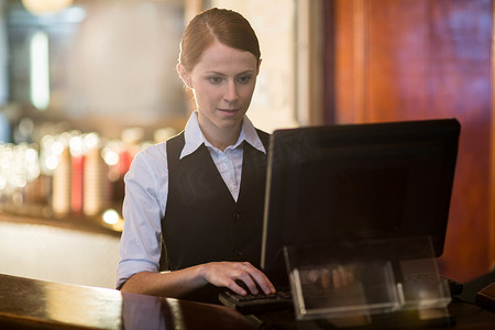 酒店女服务员摄影照片_女服务员在柜台使用电脑