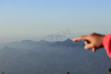 手指天空摄影照片_指着山的手指。