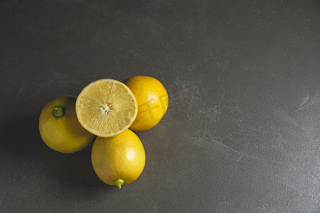 黑色桌子背景上有柠檬片的新鲜水果柠檬。