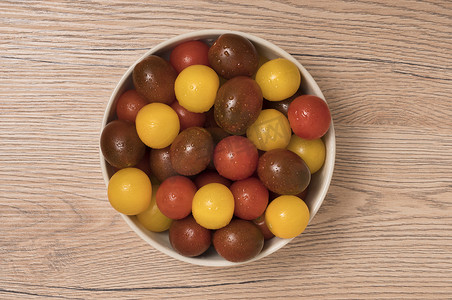 木头陶瓷碗里的樱桃番茄、红、黄和卡马托