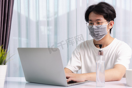 消毒凝胶摄影照片_旁边戴着带消毒凝胶的防护面具的年轻人