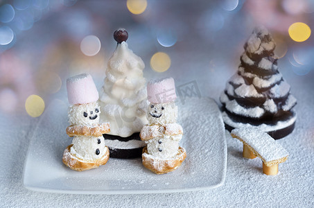 糖粉中的小蛋糕雪人和巧克力树。