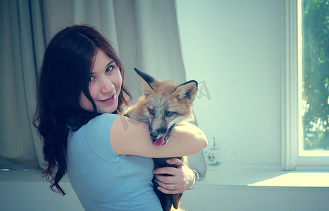 狐狸女孩摄影照片_女孩抱着狐狸。