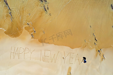 从海浪中拍摄的空中顶部和手写的新年快乐