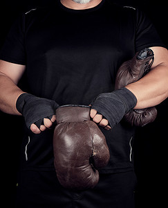 穿黑色衣服的成年肌肉男穿上皮革棕色拳击
