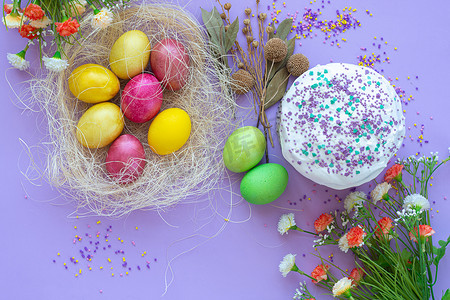 紫色背景中复活节彩蛋和蛋糕的组合物