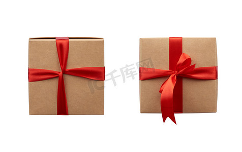 用棕色牛皮纸包裹的方形盒子，并用丝红色绑起来