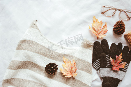 毛衣背景摄影照片_平躺的秋季时尚风格、毛衣、围巾和眼镜