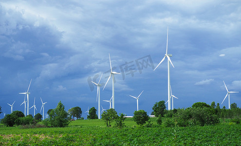 白色风力涡轮机在用于发电的绿色山脉上。清洁能源概念。
