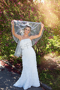 新娘礼服的秀丽新娘有花束和花边面纱的在自然。