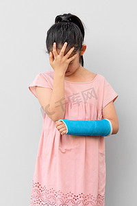 受伤女孩摄影照片_演员表中有手臂骨折的亚洲儿童，前男友伤感而悲伤
