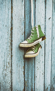 绿色经典摄影照片_一双挂在白色蕾丝上的非常古老的绿色经典运动鞋