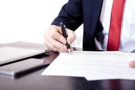 一个男人用钢笔在文件上写字的手指的低视角，概念上是沟通、通信、商业协议、法律合同或创造力