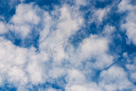 深蓝色蓝色摄影照片_深蓝色的天空，随机通风的白云