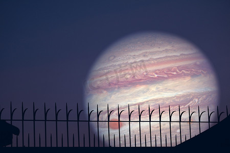木星和天空上红云的剪影金属栅栏