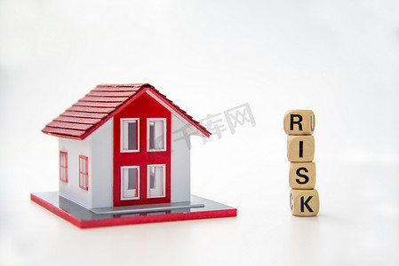 risk摄影照片_白色背景上带有“RISK”字样的木块和样板房