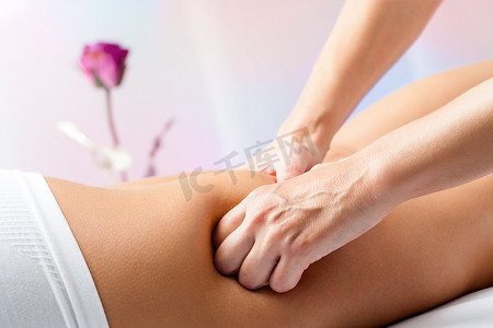 脊椎治疗摄影照片_按摩女性后大腿的手。