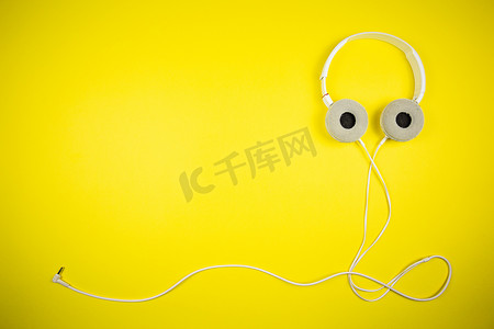 黄色背景上带 3.5 毫米线的白色音频耳机
