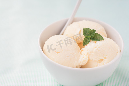 香草冰淇淋球摄影照片_用薄荷叶装饰的香草冰淇淋球