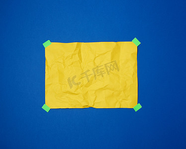 一张空的黄色皱巴巴的纸，上面粘着绿色的粘馅饼