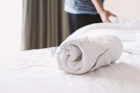 白床上的毛巾和一个男人在铺床