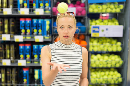 女人在运动服店购物网球。
