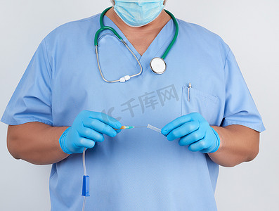 乳汁摄影照片_蓝色制服和乳汁手套的医生拿着塑料系统f