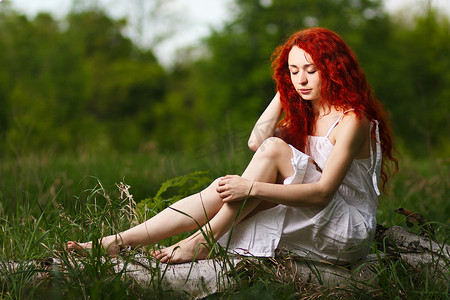 走在日落森林光芒下的红头发人女孩