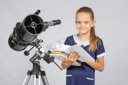 站在望远镜旁翻书的女学生天文学家