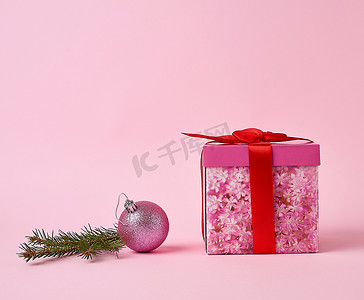有弓的桃红色礼物盒、绿色云杉分支和装饰桃红色