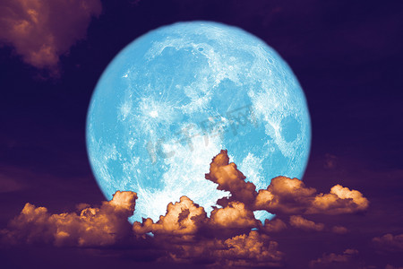 蓝色草莓月亮背在夜空中的剪影堆云上