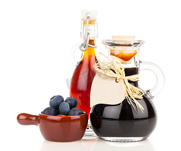 甘蔗糖浆摄影照片_玻璃、瓶子或混合物中的新鲜蓝莓和蓝莓糖浆，