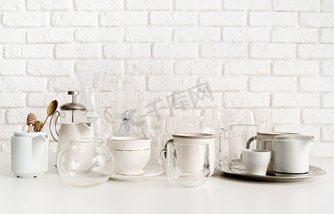 白砖墙背景桌上的陶瓷和玻璃杯和餐具