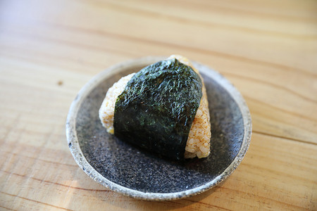 在木头背景的 Onigiri 地方日本食物