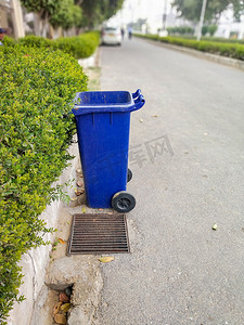 路边垃圾桶摄影照片_路边蓝色垃圾桶保持城市清洁