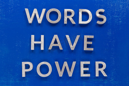 短语单词在涂有厚银色金属字母字符的蓝色涂漆板上具有力量。