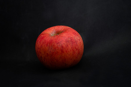 黑色背景下带水滴的新鲜红苹果，带文字空间